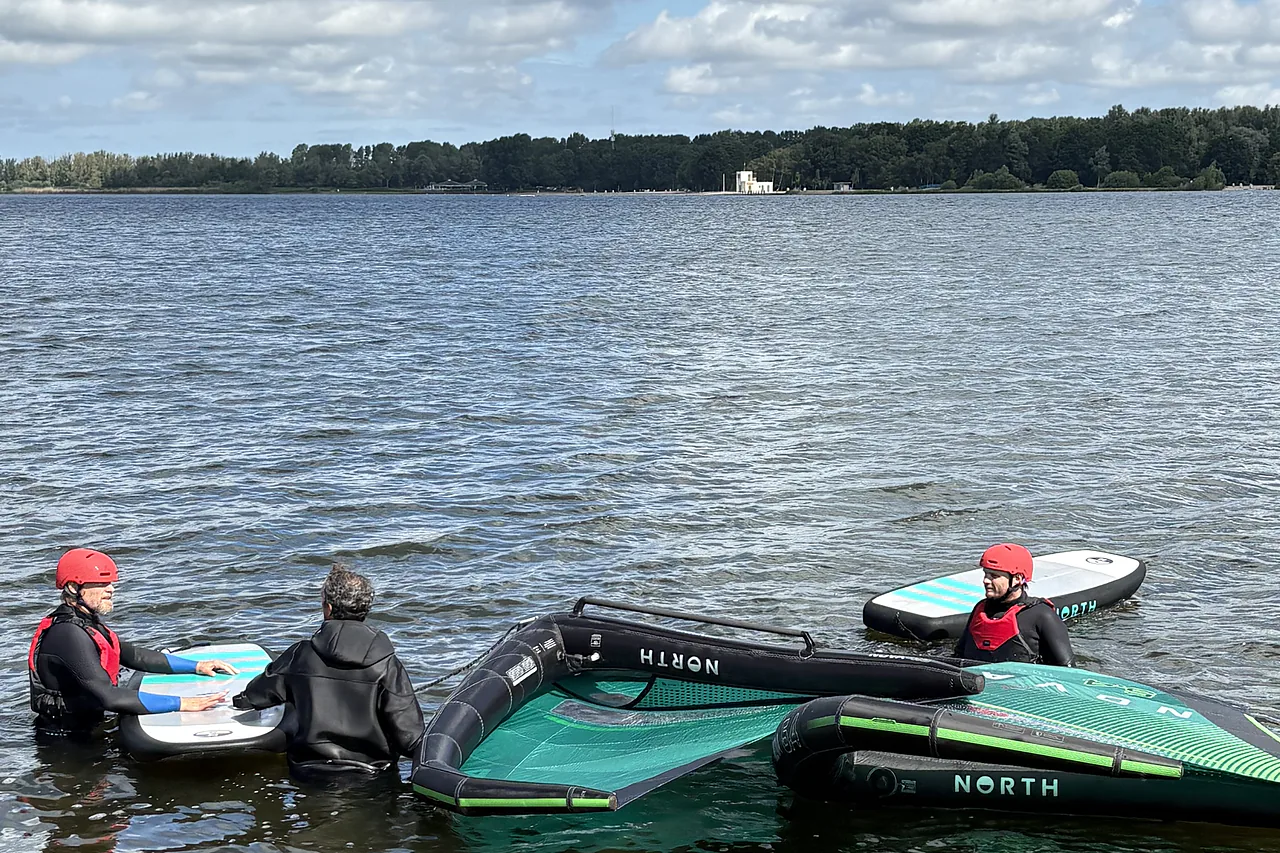 Group wingfoil lesson in the water at the lake