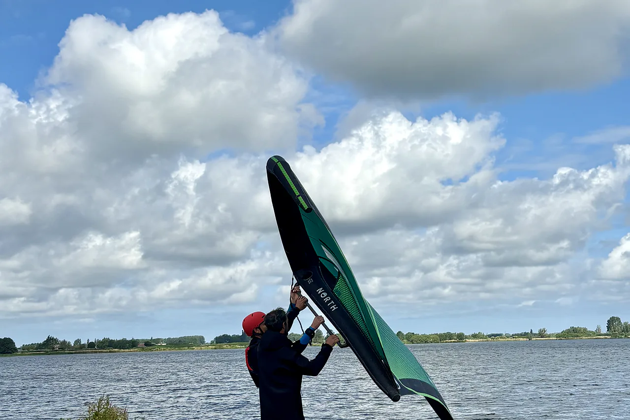 Student practising wing handling at the water's edge